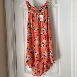 Sleeveless, round neck blouse.  Back is a little longer than front. NWT.